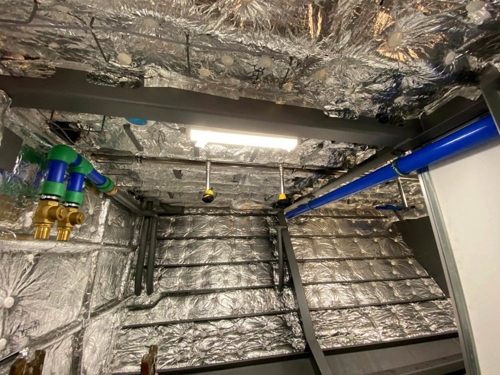 Isolierter Technikraum mit Rohrleitungen und montierten Armaturen
