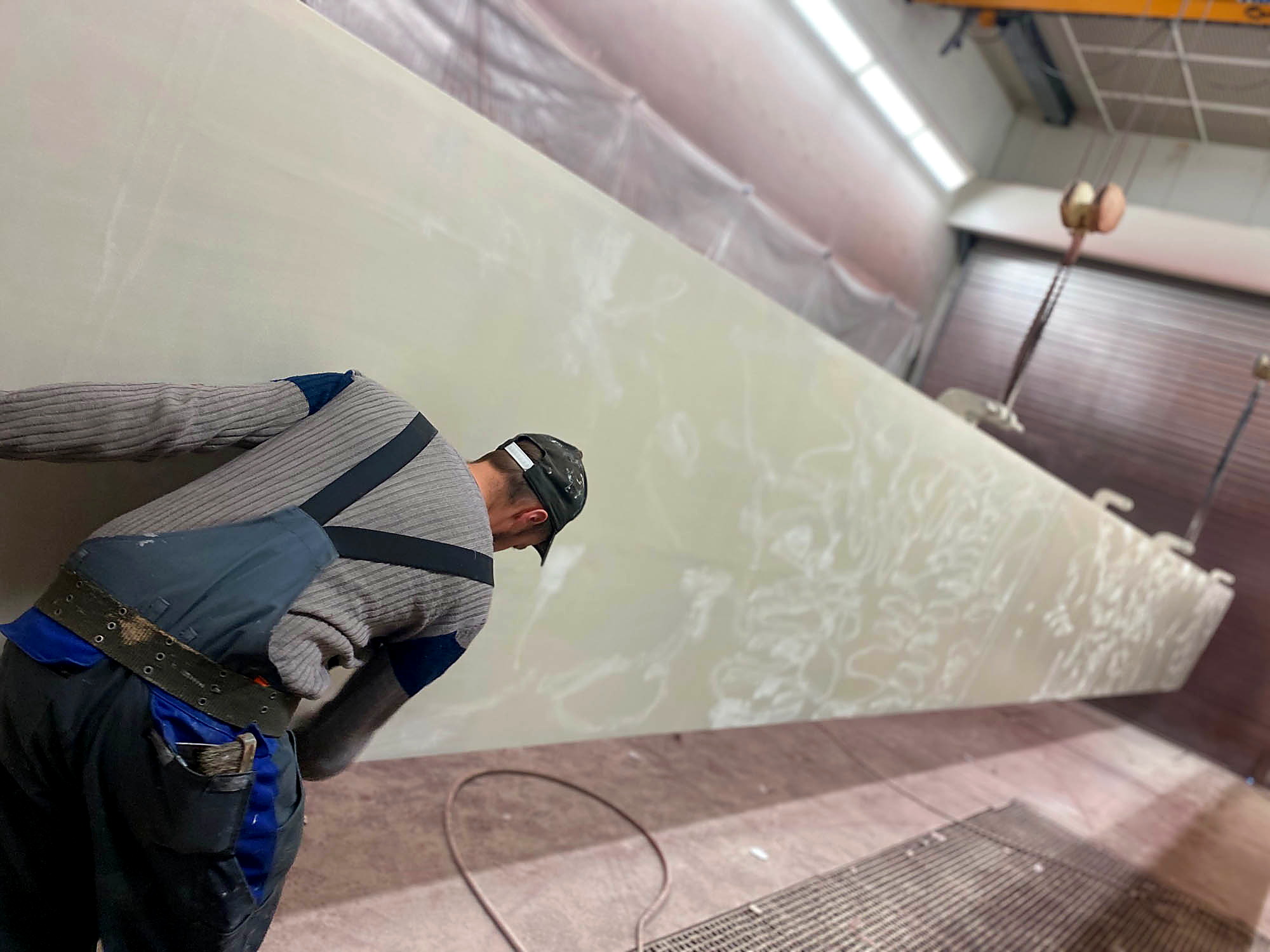 Facharbeiter kontrolliert die Oberfläche eines beschichteten Aluminium-Rumpfbauteils