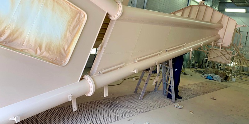 Großer Stahlträger mit hellem Decklack in der Beschichtungshalle