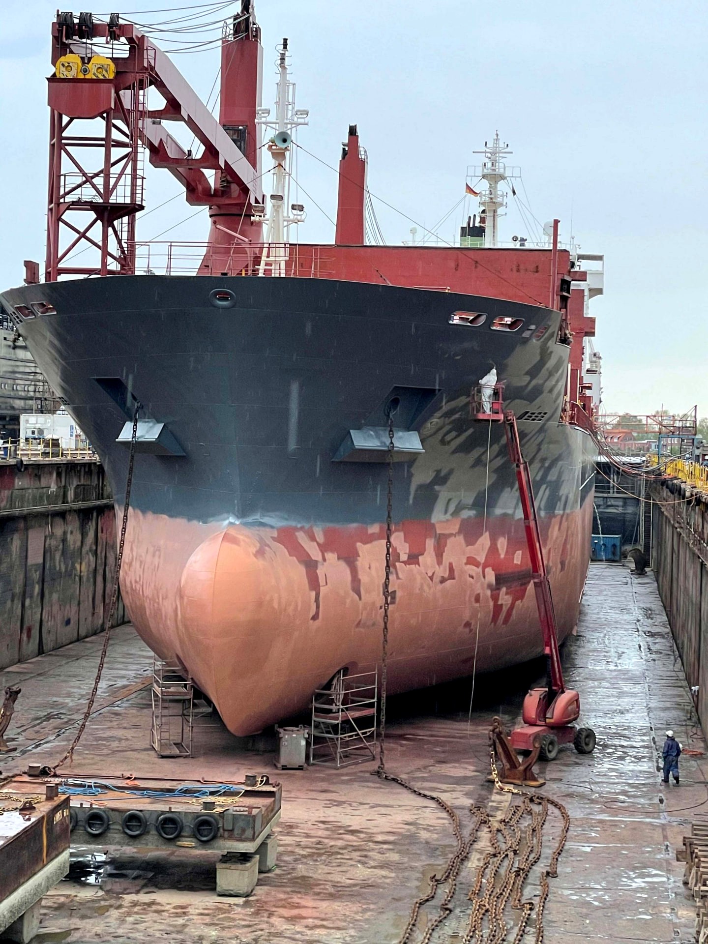 SLOMAN DISCHARGER im Trockendock während des Strahlens: teilweise entschichteter Bug mit Hubarbeitsbühne