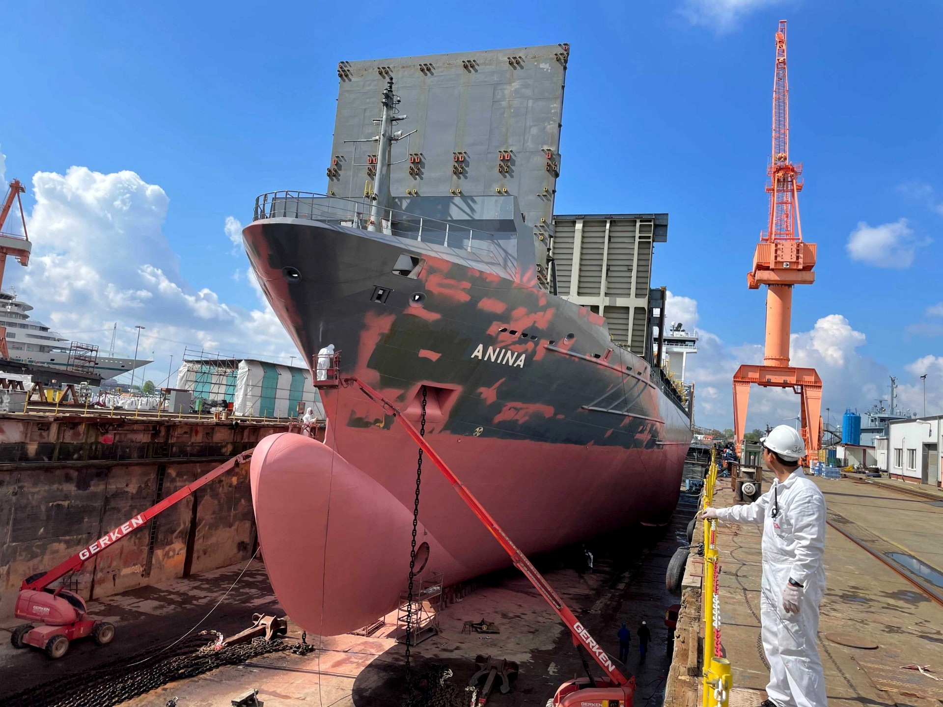 Frachtschiff ANINA im Trockendock mit teilweise gestrahltem Rumpf und Hubarbeitsbühnen