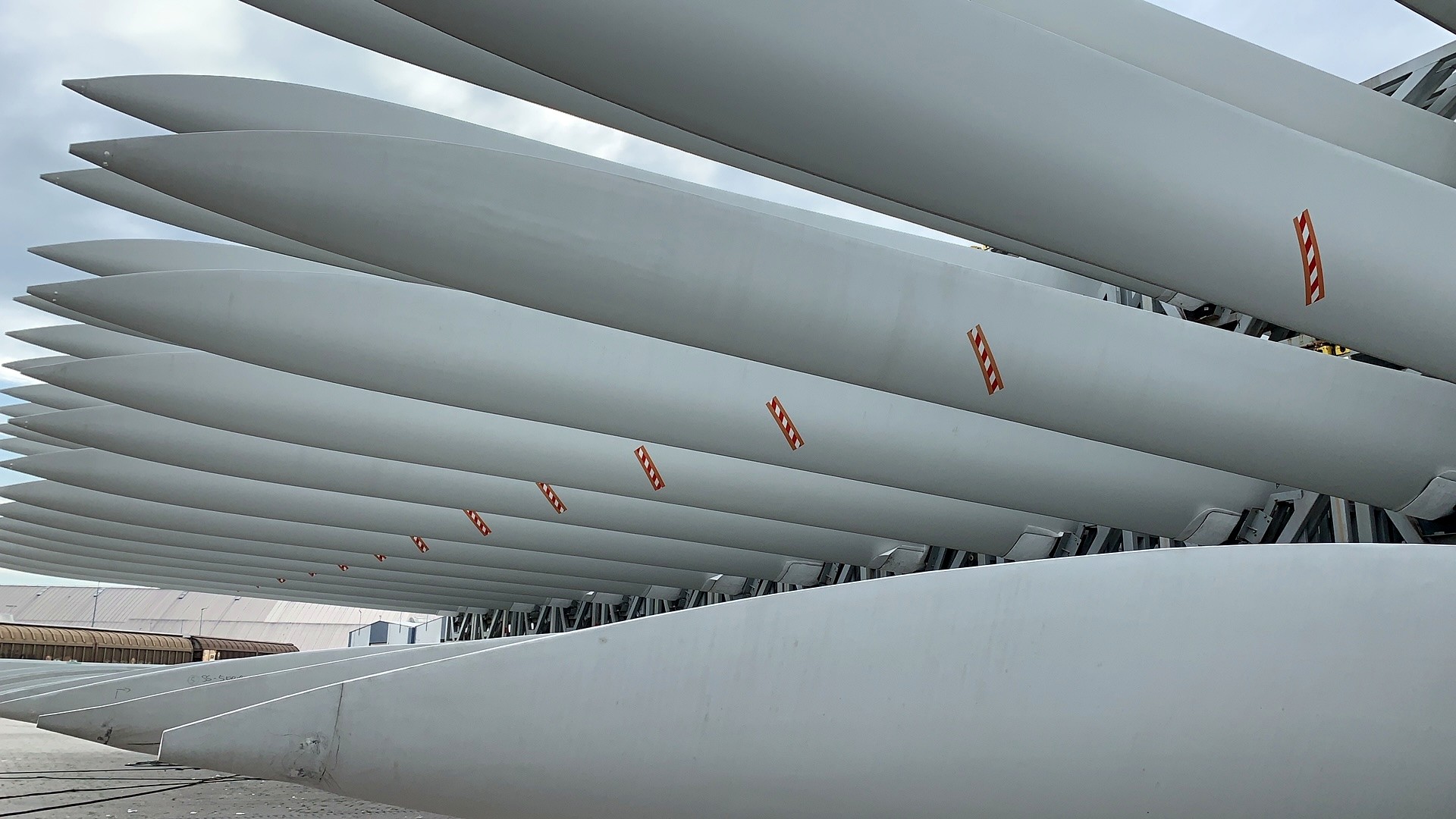 Reihe fertig lackierter Rotorblätter in der Halle nach Spachtel- und Lackierarbeiten