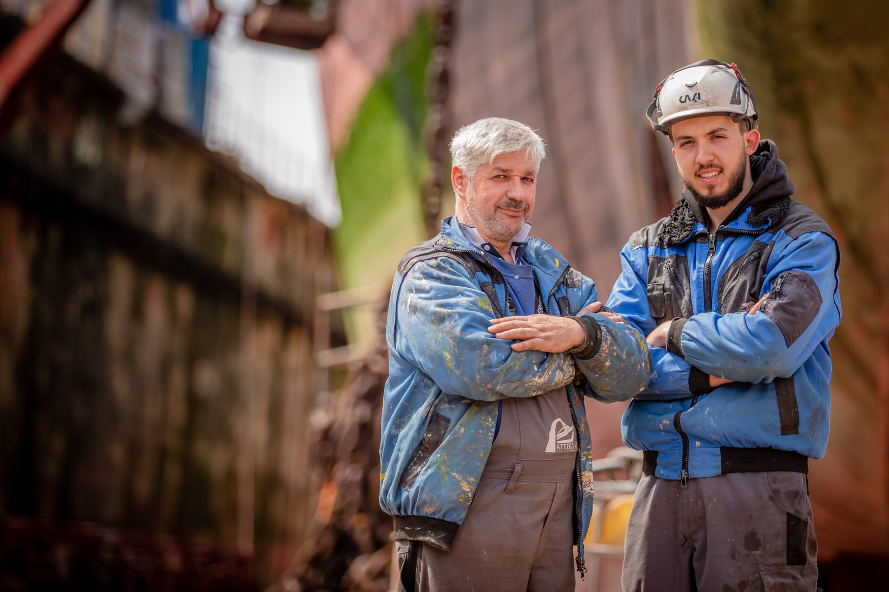 Fachkräfte der ATTIKI Industrieservice GmbH beim Beschichten eines Schiffsrumpfs im Dock